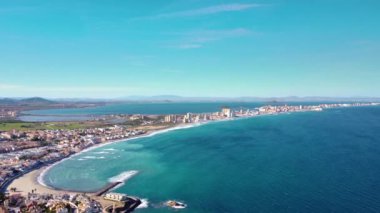 Mar Menor 'dan La Manga' nın sinematik drone görüntüsü. Murcia İspanya Bölgesi 'nde Mar Menor' un deniz kenarındaki bir kum tepesi, 21 km uzunluğunda. Seyahat güzergahı. Muhteşem manzaralı daireler ve oteller. Emlak