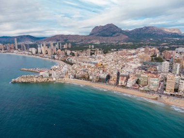 Benidorm şehrinin hava aracı bakış açısı. İspanya 'nın Alicante eyaletinde ünlü bir tatil beldesi. Gökdelenler, arka planda dağlar, Akdeniz. Bulutlu bir gün. 