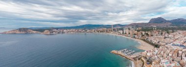 Benidorm şehrinin hava aracı bakış açısı. İspanya 'nın Alicante eyaletinde ünlü bir tatil beldesi. Gökdelenler, arka planda dağlar, Akdeniz. Bulutlu bir gün. 