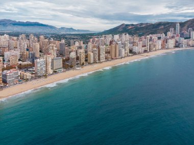 Benidorm şehrinin hava aracı bakış açısı. İspanya 'nın Alicante eyaletinde ünlü bir tatil beldesi. Gökdelenler, arka planda dağlar, Akdeniz. Bulutlu bir gün. 