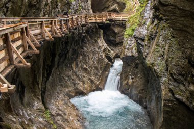 Sigmund Thun Gorge 'un güzel manzarası - Sigmund Thun Klamm. Avusturya, Kaprun yakınlarındaki Kapruner Ache 'deki Cascade Vadisi. Kristal berrak mavi su. Tahta yürüyüş patikası. 4K arkaplan, HD duvar kağıdı.