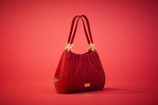 Beautiful elegant and luxury fashion leather red women handbag isolated on red background. 3d render.