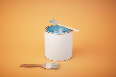 Turuncu arka planda bir kutu boya ve fırça. 3d hazırlayıcı.