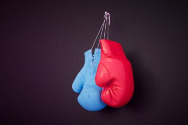 Siyah arka planda asılı kırmızı ve mavi boks eldivenleri. 3d hazırlayıcı.