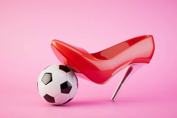 The concept of women\'s football. A red heeled shoe steps on a soccer ball. 3D render.