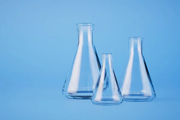 蓝色底座上装有液体或化学品的玻璃瓶 3D渲染 — 图库照片