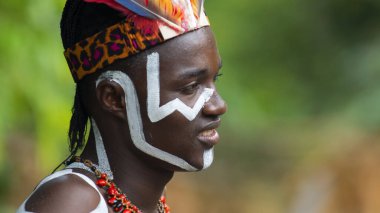 Nueva Loja, Sucumbios / Ekvador - 3 Eylül 2020: Odaklanmamış yeşil arka plana sahip bir ormanda beyaz çizgilerle çizilmiş genç siyahi bir adamın profili