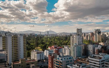 Quito şehrinin kuzey merkezinin panoramik manzarası. Bulutlu bir günbatımında La Carolina parkı merkezde. Ekvador