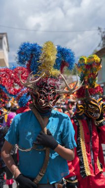 Pillaro, Tungurahua / Ekvador - 5 Ocak 2024: Pillaro kentindeki Diablada Pillarena 'da kırmızı ve mavi şeytanlar gibi giyinmiş erkeklerin portresi