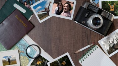 Top view of Couple photographs, passports, old camera, map and notebook on a dark wooden table clipart