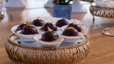 Bulanık masa arkaplanına yakın tepsiler ve çikolatalı atıştırmalıklar.