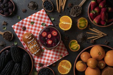 Guagua de pan 'ın en üst manzarası, bir fincan colada morada ile, ölüler günü için geleneksel Ekvador yemeği, koyu arkaplanda colada pişirmek için gerekli malzemelerle çevrili.