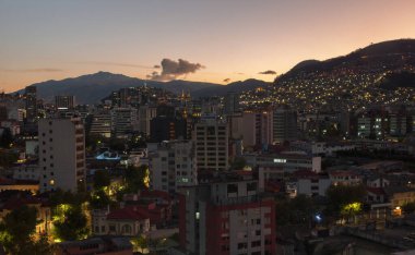 Quito 'nun kuzey kısmının panoramik manzarası akşam saatlerinde binalar aydınlanırken - Ekvador
