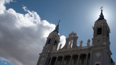 Madrid 'deki La Almudena Kilisesi ışığa karşı ve hafif bulutlu gökyüzü.