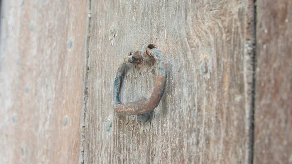 Antique wooden door with decorative metal elements. Metal doorknob.