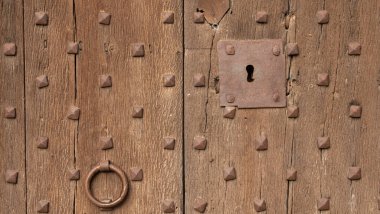 Katalonya 'da bir köyün çok eski bir kapısında eski metal kilit (İspanya).