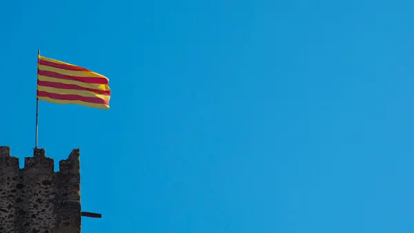 加泰罗尼亚国旗在一座中世纪古塔的蓝天上飘扬 红黄条纹旗 — 图库照片
