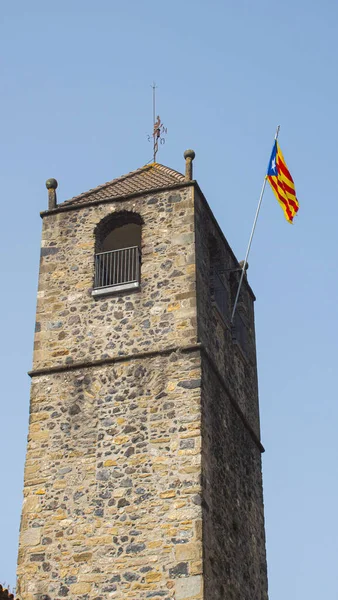 加泰罗尼亚国旗在一座中世纪古塔的蓝天上飘扬 历史建筑上的红黄条纹旗 — 图库照片