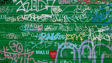 Yeşil kapının ayrıntıları okunaksız grafitilerle dolu..