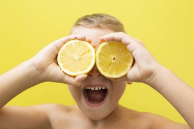 7 yaşında, sarı arka planda ağzı açık bağıran iki doğal limonlu sarışın bir çocuk..