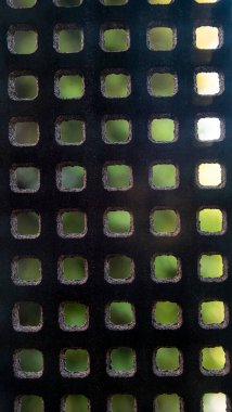 Kare ve dikdörtgen mozaikli kortizon çelik dokusu arka planda ve ağaçların yeşil arkaplanı odak dışı..