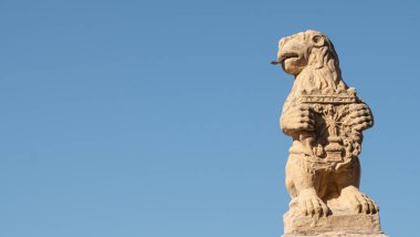 Segovia şehrinde dili sarkık ve kraliyet kalkanı olan bir taş aslan heykeli (İspanya))