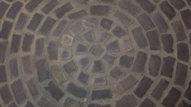 Çembersel şekil oluşturan kaldırım taşlı bir zeminin dokusu