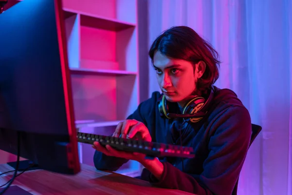 stock image Handsome boy playing E-Sport game or streamer, Enjoying playing online games, Entertainment  or technology game trends, Live show play games, Focus monitor, Blue and red lights.