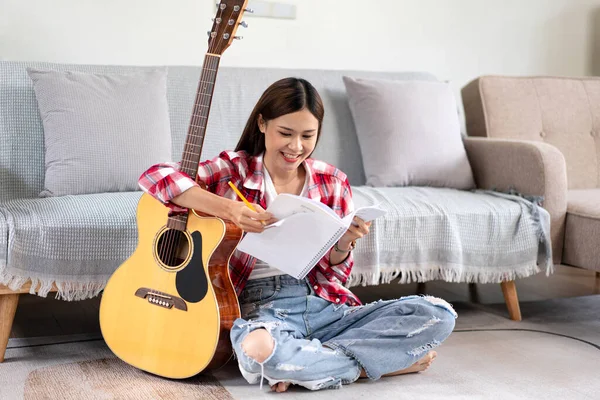 Jovem Mulher Compor Música Escrever Letras Notebook Enquanto Coloca Guitarra — Fotografia de Stock