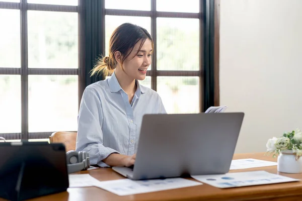 女性自由职业人士在办公室客厅的桌子上工作时 在笔记本上阅读商业信息 在笔记本电脑上输入数据 — 图库照片