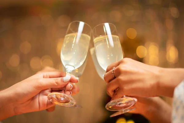 stock image Hands of young people clinking with glass of champagne to celebrate and toasting with happiness in holiday of new year party at home.