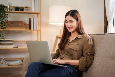 Çalışma ve video konferansında iş arkadaşlarıyla birlikte çalışan bayan girişimci, ev ofisinin oturma odasında dizüstü bilgisayarla yeni iş projesini tartışıyor ve tartışıyorlar..