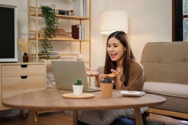 Çalışma ve video konferansı sırasında iş arkadaşlarıyla birlikte çalışan bayan girişimci ev ofisinin oturma odasında rahat bir şekilde oturmak üzere dizüstü bilgisayarla yeni iş projesini tartışıyor..