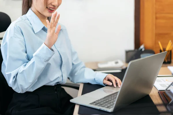 在现代写字楼里 女商人正在用笔记本电脑与同事们举行视频会议 与同事们交流商业信息 同时研究新的商业项目 — 图库照片