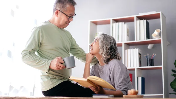 Seniorenpaar Sitzt Hause Wohnzimmer Trinkt Kaffee Und Schaut Sich Beim — Stockfoto