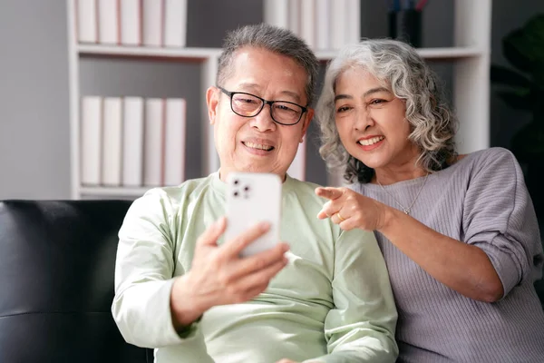 Seniorenpaar Ist Videokonferenz Mit Familie Und Zeigt Auf Das Smartphone — Stockfoto