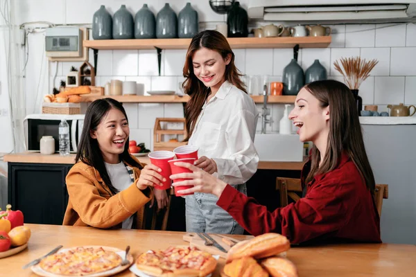 一群朋友一边喝酒 一边一起吃意大利披萨和面包 一边在家里的厨房里享受周末派对的乐趣 — 图库照片