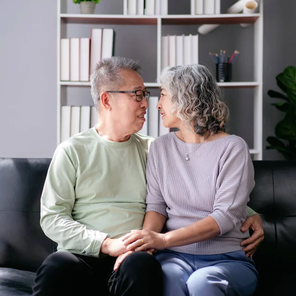 Idősebb Pár Egymás Szemébe Néz Szeretettel Ölelkeznek Miközben Kanapén Ülnek — Stock Fotó