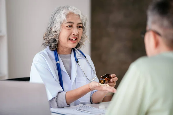 Kadın Doktor Elinde Ilaç Kullanımını Açıklamaya Yaşlı Bir Hastaya Sağlık — Stok fotoğraf