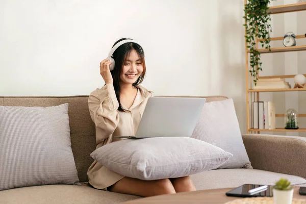 Női Vállalkozó Nagy Kényelmes Kanapén Laptopot Tesz Párnára Miközben Fejhallgatót — Stock Fotó