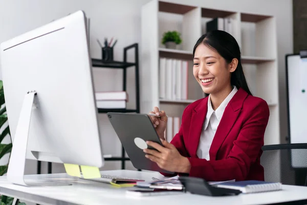 穿着西服的女商人在现代工作场所的桌子上工作时 对新业务的会计思考很多 比如在平板电脑上写想法 在电脑上打字 — 图库照片