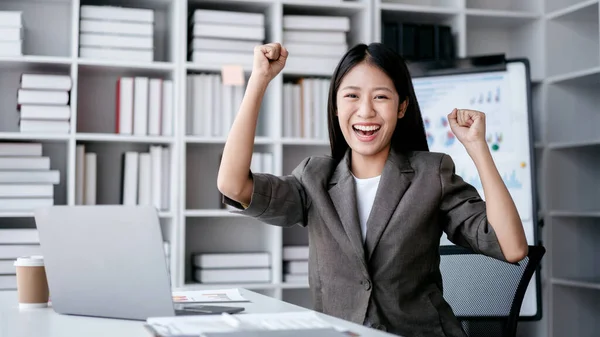 stock image Accounting business concept, Accountant woman excited and raising fist to celebrate achievement while working about investment with business planning finance.