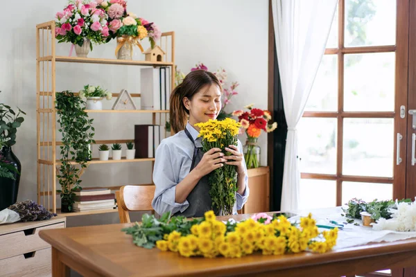 Florista Feminina Avental Segurando Crisântemo Amarelo Cheirar Flor Com Frescura — Fotografia de Stock