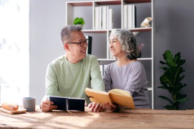 Üst düzey bir çift evde oturma odasında oturup birbirlerinin gözlerinin içine bakar ve birlikte kitap okurken keyif alır ve birlikte emeklilikte dinlenmek için zaman harcarlar..