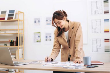 Modern ofis dizüstü bilgisayarında inşaat projesini planlarken tasarım ve tasarım için çalışan kadın mimar..