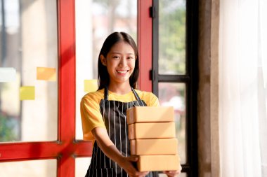 Küçük işletme paket teslimatı konsepti, kadın girişimci müşteri için teslimat yapmak için kahverengi karton kutu tutuyor..