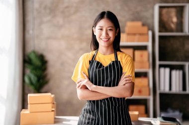 Küçük işletme paket teslimatı konsepti, güveni olan kadın girişimci, müşteriler için sevkiyat yapmak üzere ürün paketlerken, iç işlerinde çevrimiçi satış ticareti hakkında çalışıyor..