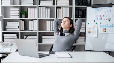 Teknoloji yaşam tarzı kavramına sahip iş kadını, iş kadını boynuna kulaklık takıyor ve işten sonra dinlenmek için kafasının arkasından el ele tutuşuyor..