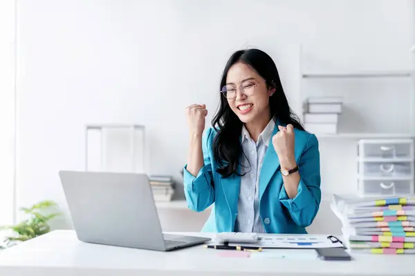 会计行业的理念 会计女性在与商业规划金融打交道的同时 一边兴奋地举起拳头 一边在笔记本电脑上看到好消息 一边庆祝自己的成就 — 图库照片