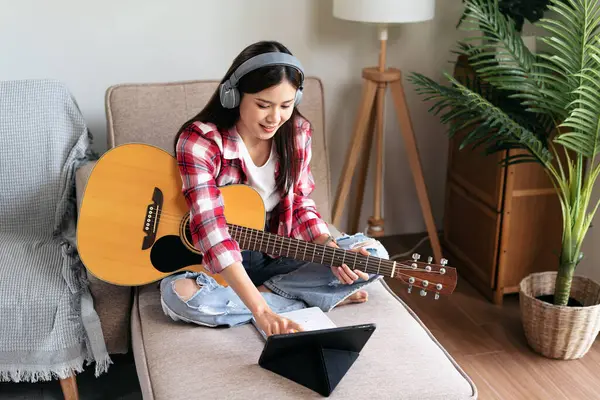 Młoda Kobieta Gra Gitarze Ćwiczy Śpiewania Piosenki Podczas Noszenia Słuchawki — Zdjęcie stockowe